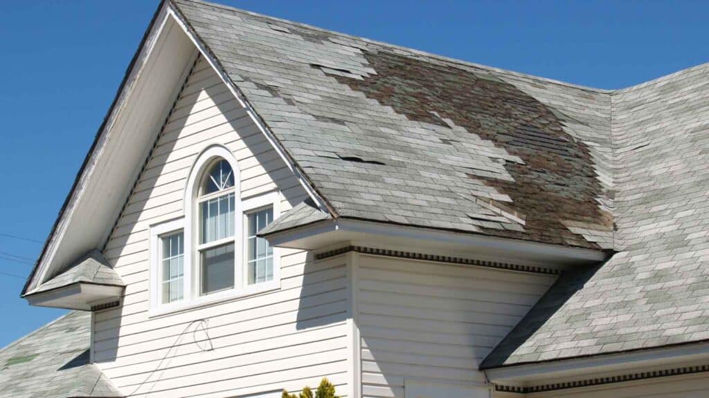 Damaged roof with missing shingles needing repair.