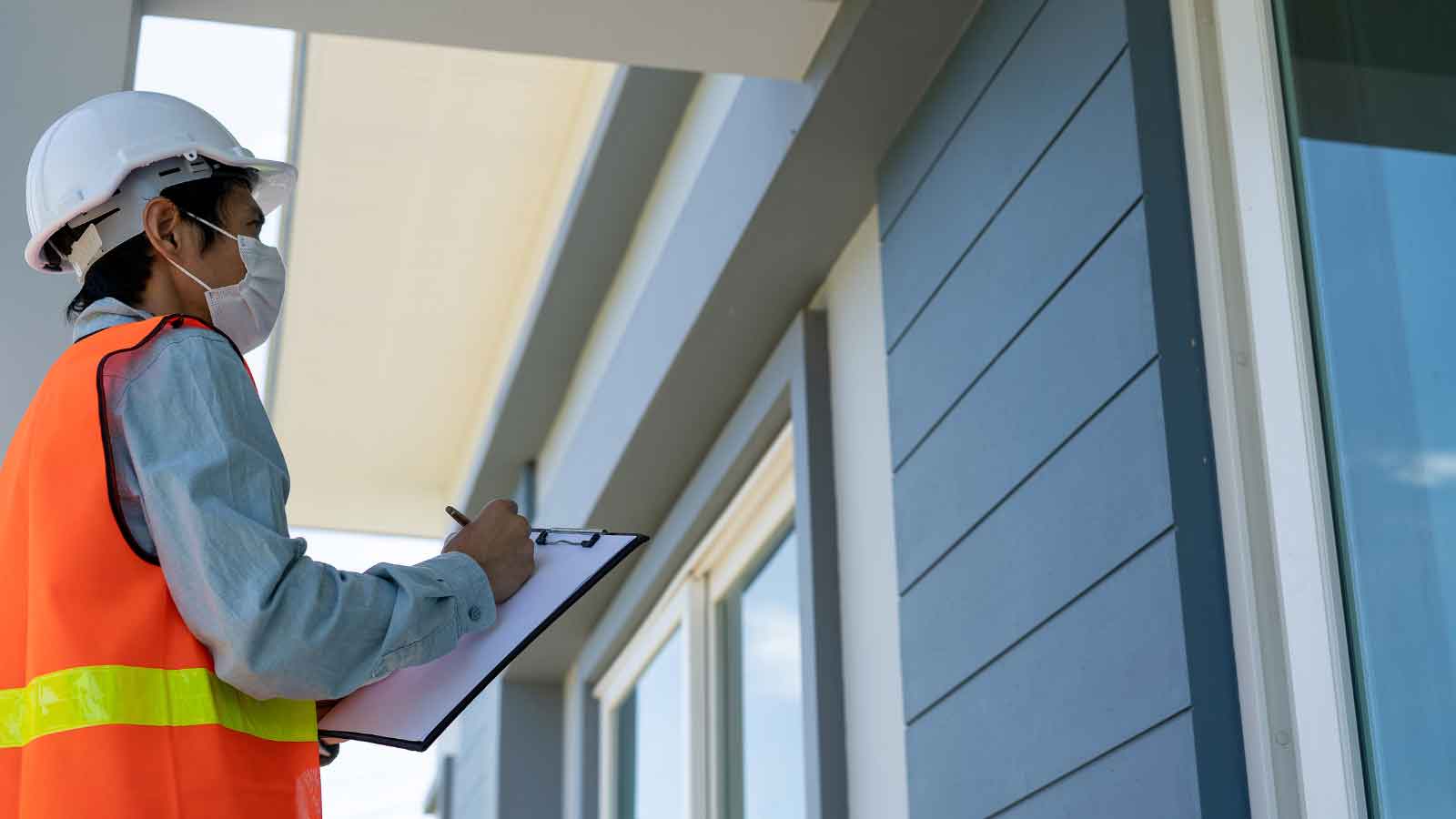 Inspector conducting an exterior property evaluation with a checklist.