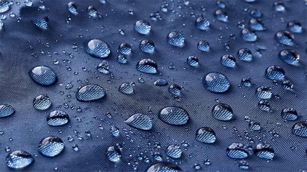 Water droplets beading on a waterproof fabric surface.