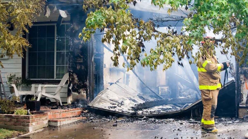 Firefighter assessing damage after a house fire