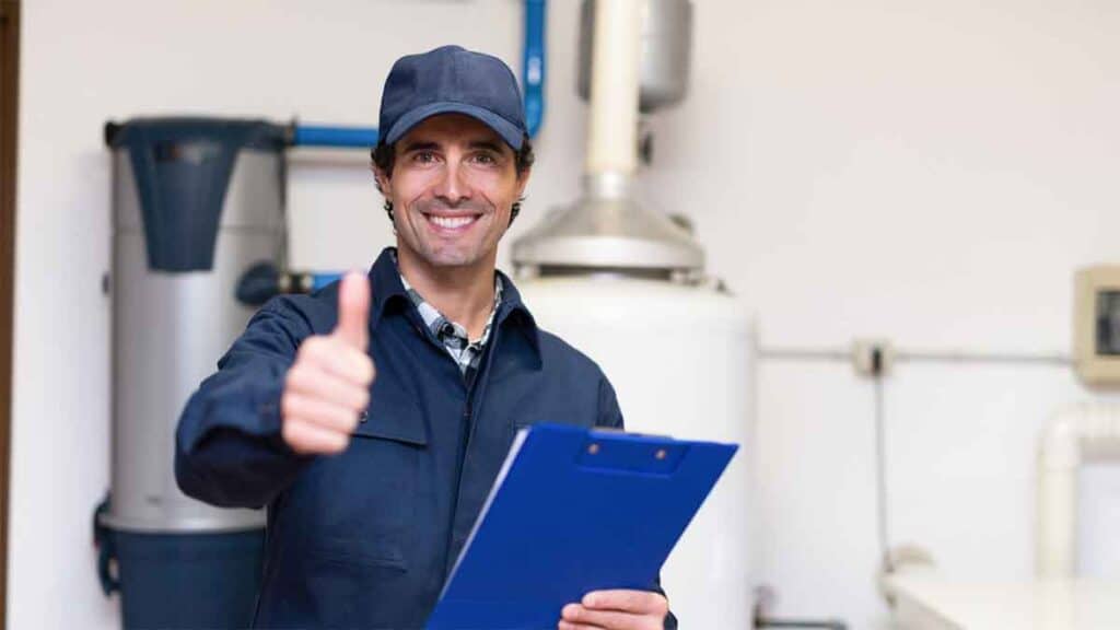 Smiling technician gives thumbs up while holding a clipboard.
