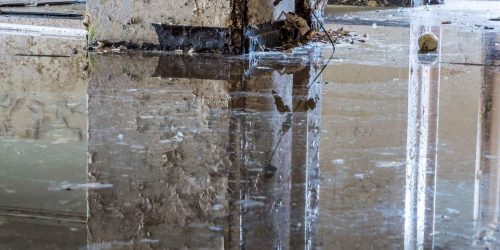 Flooded interior with visible water damage on walls and floor.