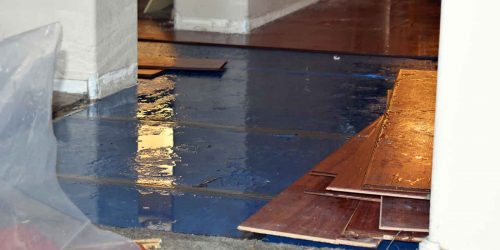 Water-damaged flooring being removed due to indoor flooding